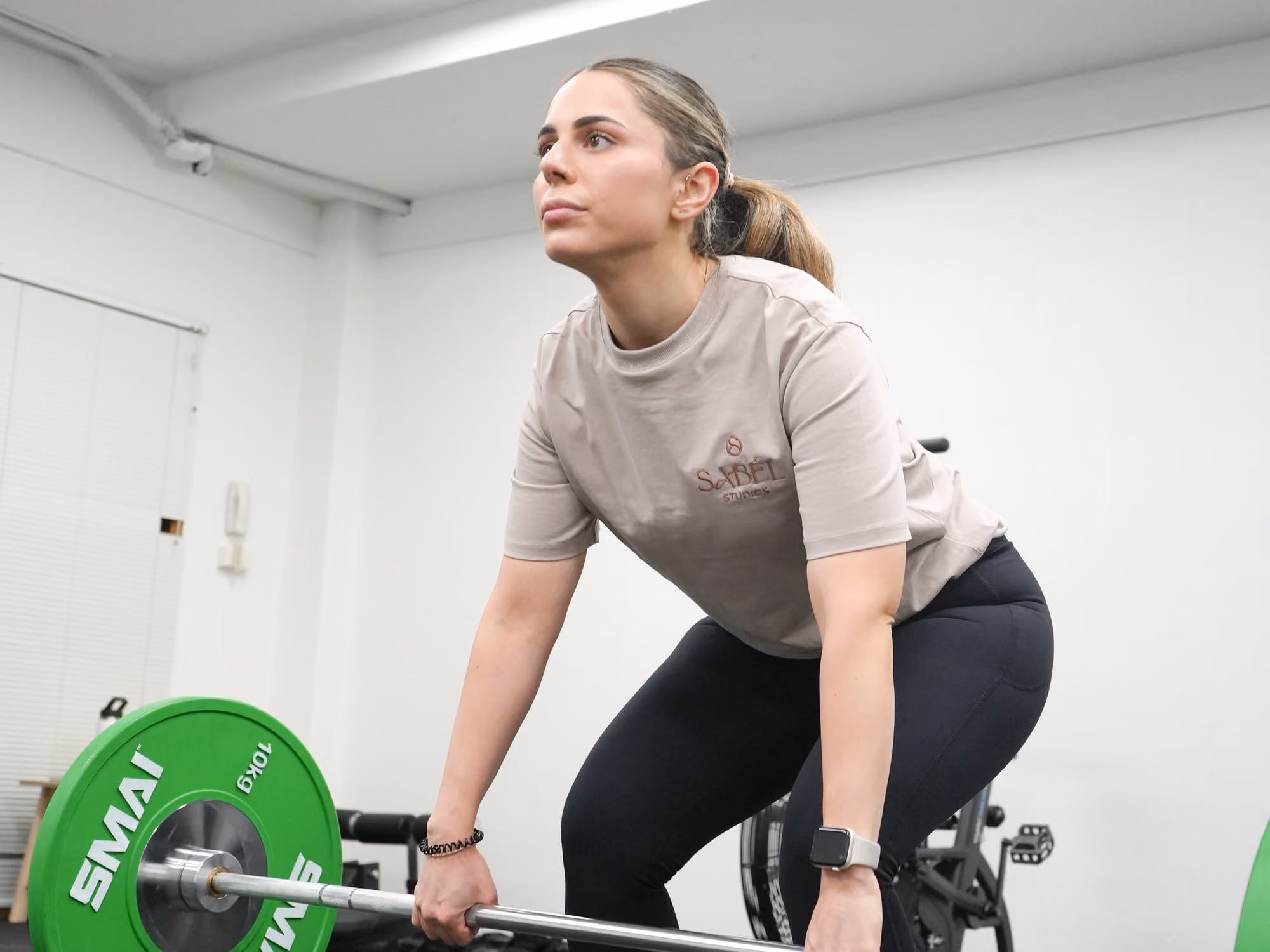 A member setting up for a barbell deadlift in the strength and conditioning space at Sabél Studios