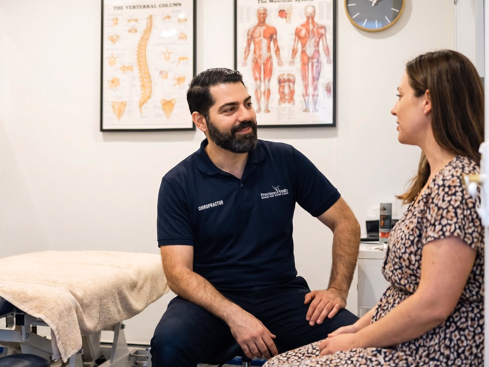 Practitioner assessing a client's shoulder range of movement in the treatment room at Sabél Studios