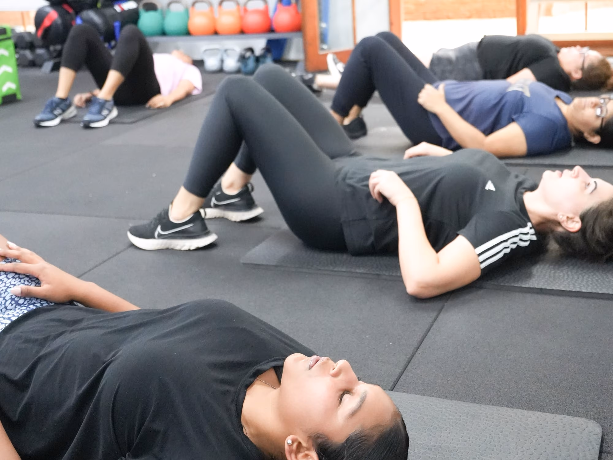 Members lying back on their mats with knees bent during a Mat Pilates class at Sabél Studios