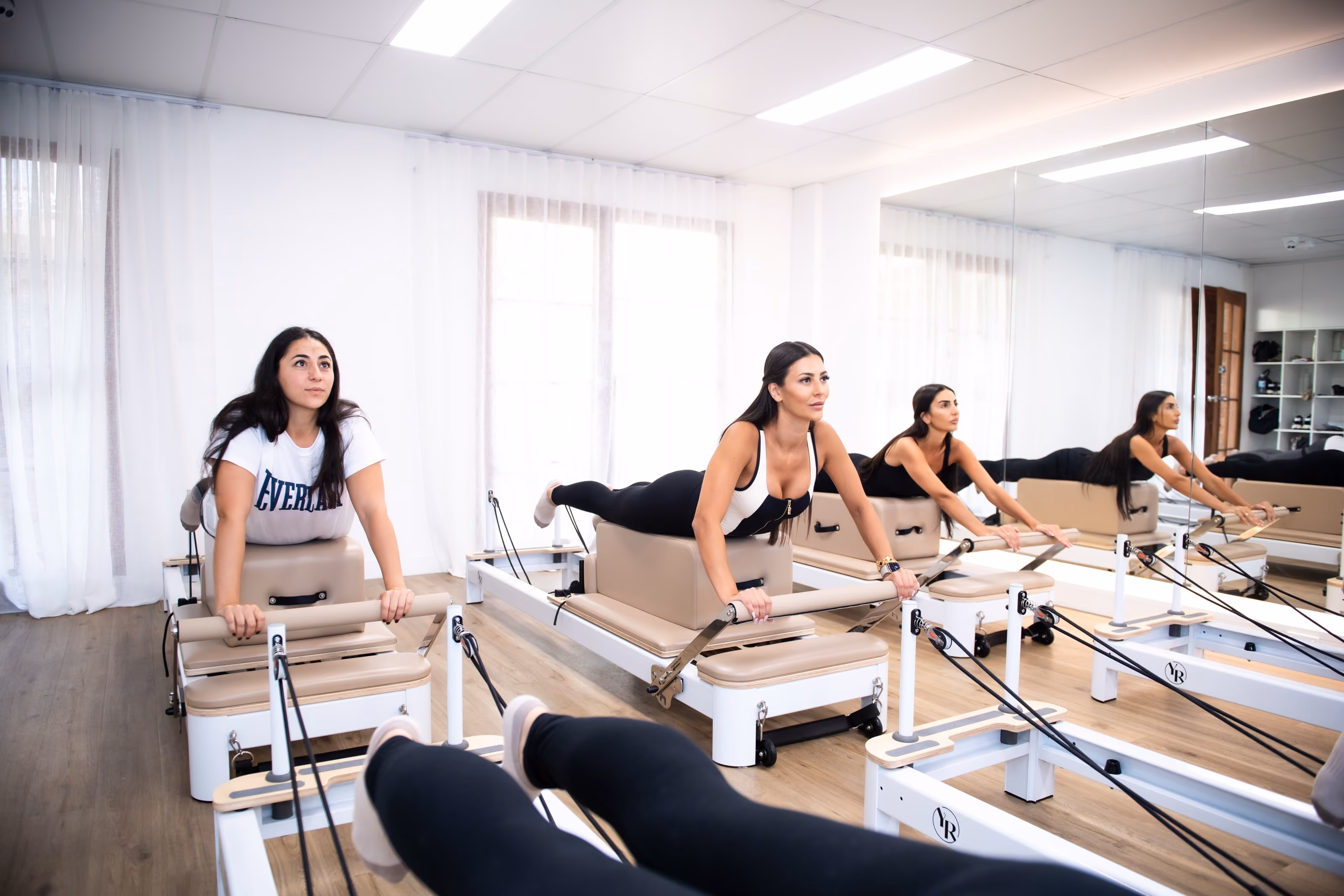 Women taking part in a Reformer Pilates class at Sabél Studios